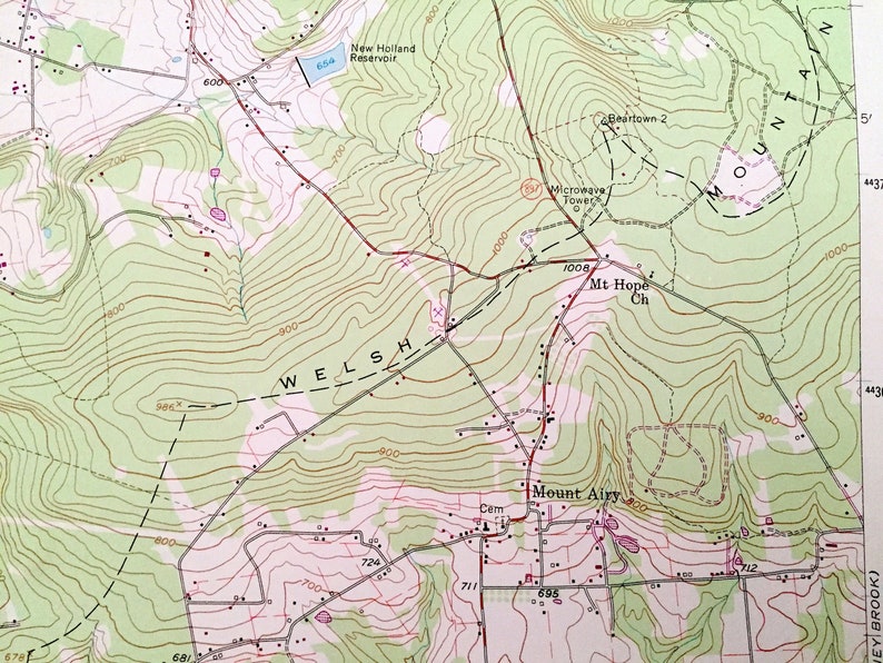 Op de afbeelding: Een topografische kaart die het gebied rond Mount Airy, het New Holland Reservoir en de Mt Hope Church laat zien. De kaart toont hoogtelijnen, wegen en andere geografische kenmerken. De tekst "WELSH" is zichtbaar op de kaart.
