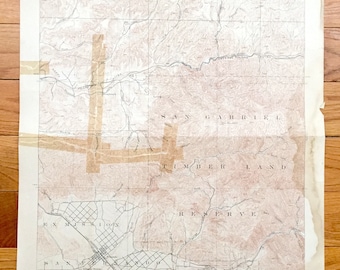 May include: A vintage topographic map of the San Gabriel Mountains in California. The map shows the San Gabriel Timberland Reserve, the Tujunga Valley, and the San Fernando Valley. The map is printed on a cream-colored paper with brown ink.