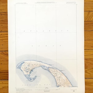 Può includere: Una mappa d'epoca di Cape Cod, Massachusetts, con l'Oceano Atlantico e la baia di Cape Cod. La mappa è stampata su carta invecchiata con dettagli blu e marroni e include nomi di luoghi come Provincetown e Truro.