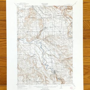May include: A vintage topographic map of a geographical area, featuring detailed contour lines, roads, and waterways. The map is printed on aged paper, with text indicating the United States Department of the Interior and State of Oregon. The map is a detailed representation of the terrain.