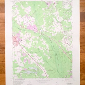 Puede incluir: Un mapa topográfico vintage del área de Williamsburg, Nueva Jersey. El mapa muestra carreteras, ríos y otras características geográficas. El mapa está impreso en un fondo blanco con líneas verdes y rosadas.