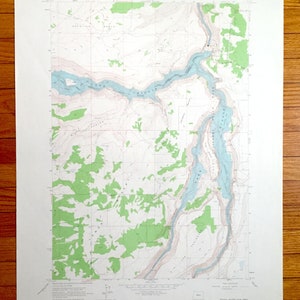 May include: A vintage topographic map of the Snake River in Idaho, showing the river's course, elevation contours, and surrounding terrain. The map is printed on paper and has a light blue and green color scheme.