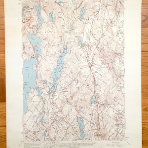 May include: A vintage topographic map of Gray, Maine, featuring a detailed depiction of the area's lakes, rivers, and terrain. The map is printed on cream-colored paper and includes a legend and scale.