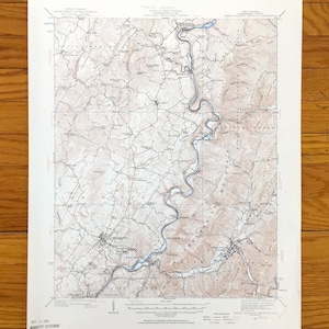 Könnte beinhalten: Eine alte topografische Karte mit einer detaillierten Darstellung eines Flusses, der sich durch eine bergige Region schlängelt. Die Karte zeigt Höhenlinien, Straßen und Ortsnamen, gedruckt in Braun-, Blau- und Weißtönen. Die Karte ist datiert und enthält den Namen der ausstellenden Behörde.