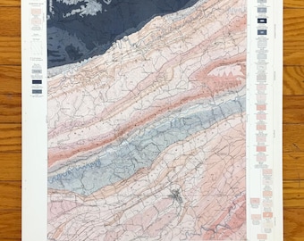 May include: A vintage geological map titled "Economic Geology Sheet" with a detailed, colorful illustration. The map features shades of pink, blue, and brown, with a legend and text along the edges. The map is on a white paper.