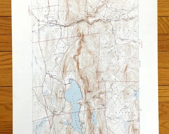 Könnte beinhalten: Eine alte topografische Karte von East Middlebury, Vermont, die das Gebiet um den East Middlebury Lake zeigt. Die Karte ist auf weißem Papier mit braunen Höhenlinien und blauen Wassermerkmalen gedruckt. Die Karte trägt den Titel "East Middlebury VT" und enthält eine Skala und eine Kompassrose.