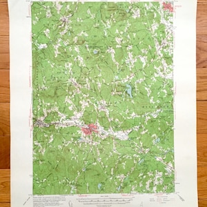 May include: A vintage topographic map of Milford, New Hampshire, showing the surrounding towns of New Boston, Mont Vernon, Amherst, Merrimack, Bedford, and Hollis. The map is printed on white paper with green and brown lines and text.