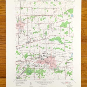 Könnte beinhalten: Eine Vintage-topografische Karte von Lancaster, New York, die Straßen, Flüsse und andere geografische Merkmale zeigt. Die Karte ist auf weißem Papier mit grünen und braunen Linien und Text gedruckt. Die Karte trägt den Titel "Lancaster Quadrangle" und enthält den Text "Geography Department Map Library, Wisconsin State University, 1:24,000 Scale".