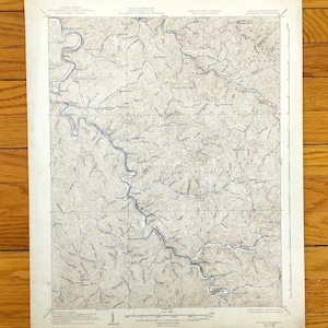 Op de afbeelding: Een vintage topografische kaart van de Appalachen in West Virginia. De kaart toont rivieren, beken en hoogtelijnen. De kaart is gedrukt op papier en heeft een bruin en wit kleurenschema.