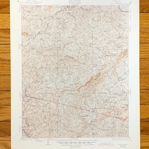 Op de afbeelding: Een vintage topografische kaart van de Rocky Mount Quadrangle in Virginia. De kaart toont het terrein, de wegen en waterwegen van het gebied. De kaart is gedrukt op papier en heeft een bruin en wit kleurenschema.