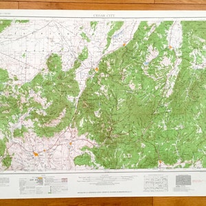 Może przedstawiać: Antyczna mapa topograficzna Cedar City w stanie Utah, przedstawiająca teren i cechy obszaru. Mapa jest wydrukowana na białym papierze z zielonymi i brązowymi liniami i tekstem. Mapa nosi tytuł "CEDAR CITY" i ma skalę 1:250 000.
