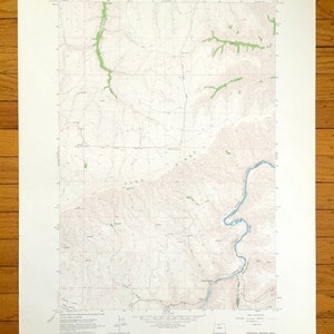 May include: A vintage topographic map of the Sherars Bridge Quadrangle, Oregon, from the U.S. Department of the Interior. The map features contour lines, a river, and green shaded areas, likely representing vegetation. The map is printed on aged paper.