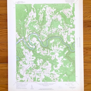 May include: A detailed topographic map showing a river and surrounding landscape, with green and blue hues. The map includes contour lines and text indicating geographical features. The map is printed on white paper, with text in the corners.