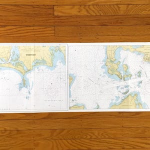 Può includere: Una carta nautica dettagliata con illustrazioni di aree costiere, con il testo "Westport" e il numero "23". La carta mostra masse terrestri in beige e verde, circondate da acqua blu, con numerosi indicatori di navigazione.