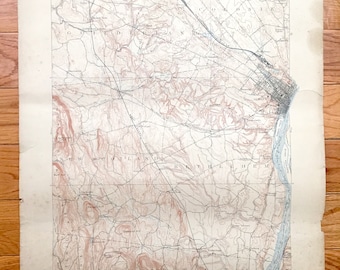 May include: A vintage map of the New York area, showing the towns of Cohoes, Waterford, and West Albany. The map is printed on paper and has a light brown color. The map shows roads, rivers, and other geographical features.