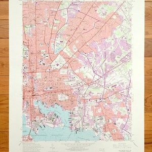 Może przedstawiać: Antyczna mapa Baltimore East w stanie Maryland, przedstawiająca ulice, drogi i szlaki wodne. Mapa jest wydrukowana na papierze i ma jasnoróżową i fioletową kolorystykę. Mapa nosi tytuł "Baltimore East MD" i zawiera tekst "United States Department of the Interior Geological Survey" oraz "United States Corps of Engineers".
