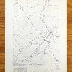 May include: A vintage topographic map of Brasher Falls, New York, showing roads, rivers, and elevation contours. The map is printed on white paper with blue lines and text. The map is titled "Brasher Falls, New York" and includes a scale bar and legend.