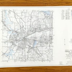 May include: A detailed highway map of Tarrant County, Texas, showing roads, highways, and waterways. The map is in black and white with blue water features, and includes a legend and scale. The map is on a white background.