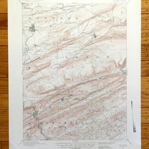 Puede incluir: Un mapa topográfico antiguo de Pensilvania, que muestra los condados de Luzerne, Carbon y Schuylkill. El mapa muestra líneas de contorno, ríos y nombres de lugares en una impresión detallada en tonos sepia. El mapa está impreso en papel envejecido.