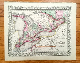 May include: An antique map of Ontario, Canada, showing the counties and major waterways. The map is printed in black and white with colored accents, including pink, green, and yellow. The map is surrounded by a decorative border.