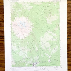 May include: A topographic map of the Shasta, California area, showing the location of Mount Shasta and surrounding national forest. The map is printed in black and white with green and pink contour lines.