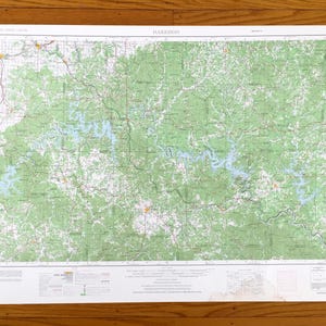 Puede incluir: Un mapa topográfico detallado de Harrison, con áreas forestales verdes, vías fluviales azules y una red de carreteras. El mapa está impreso en papel blanco e incluye el nombre "Harrison" en la parte superior.
