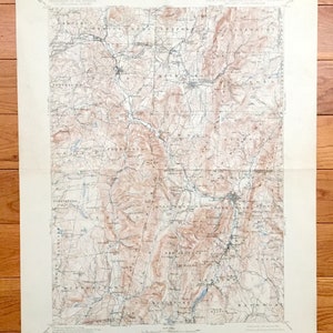 Puede incluir: Un mapa topográfico vintage de la región de Nueva York, Massachusetts y Vermont. El mapa muestra el terreno con líneas de contorno marrones y ríos y arroyos azules. El mapa está titulado "Nueva York, Massachusetts, Vermont, Taconic Quadrangle".