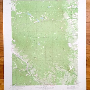 May include: A vintage topographic map of the Pike National Forest in Colorado. The map is printed on white paper with green and brown lines indicating elevation and terrain. The map includes the text "Pike National Forest" and "Cascade, Colorado".
