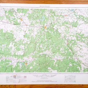 May include: A vintage map of Brownwood, Texas, printed on white paper with green and red markings. The map shows roads, rivers, and other geographical features. The map is titled "Brownwood" in the upper left corner.