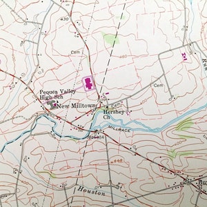 Op de afbeelding: Een vintage kaart van een landelijk gebied met een rivier, wegen en gebouwen. De kaart toont de locatie van Pequea Valley High Sch, New Milltown, Hershey Ch en Buyerstown. De kaart bevat ook een schaal en een legenda.