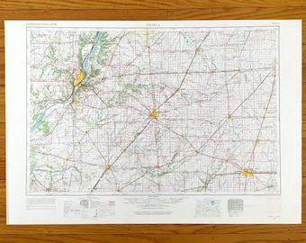 May include: A detailed map of Peoria, Illinois, featuring a network of roads, rivers, and geographical features. The map is printed on white paper and includes the city's name at the top. The map is set against a wooden background.