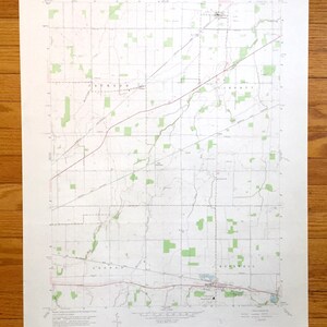 May include: A vintage topographic map of Jackson, Liberty, and Hopewell, Michigan. The map is printed on white paper with green and red lines. The map shows the location of roads, rivers, and other features. The map is dated 1958.