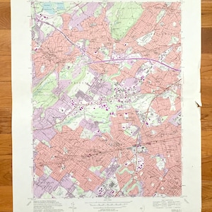 Może przedstawiać: Antyczna mapa obszaru Spring Valley, Nowy Jork. Mapa jest wydrukowana w czerni i bieli z różowym i zielonym cieniowaniem. Mapa przedstawia drogi, rzeki i inne cechy geograficzne. Mapa nosi tytuł "Spring Valley, Nowy Jork" i jest częścią serii "United States Geological Survey".