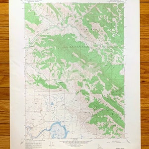 Puede incluir: Un mapa topográfico vintage del cuadrángulo de Herman en Idaho, que muestra el Bosque Nacional Caribou y el área circundante. El mapa está impreso en papel y tiene un esquema de color verde y blanco.