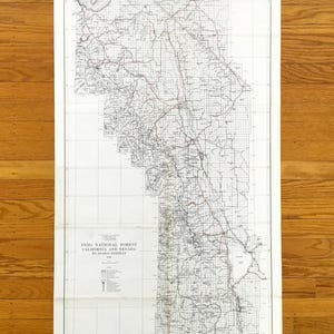 May include: Vintage map of Inyo National Forest, California and Nevada, with detailed roads, lakes, and geographical features. The map is printed in black and red ink on aged paper, with the title at the bottom.