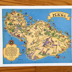 以下が含まれることがあります： ハワイのマウイ島のヴィンテージな漫画の地図。地図には人々、動物、ランドマークが描かれています。地図の上部には「Island of Maui」という文字があります。テキスト「This Cartograph is to serve as a guide to some of the good times to be found on the Valley Island. That is the Island of Maui. You have a double where you will see the two places named on top, then you can check down from that and observe a plain that's charted on the back of the dessert, a great pride on earth.」