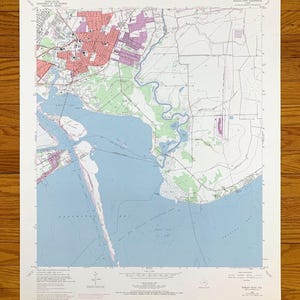 May include: A vintage map of Morgan Point, Georgia, showing the surrounding area, including the coastline, rivers, and roads. The map is printed on white paper with blue, green, and pink lines and text.