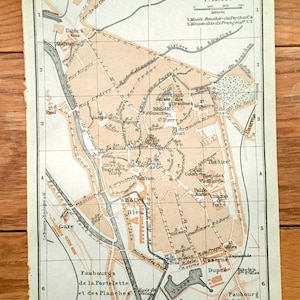 May include: An antique map of Abbeville, France, printed in black and white with red and orange highlights. The map shows the city's streets, buildings, and landmarks, including the river Somme, the Gare (train station), the Hotel Dieu (hospital), and the Faubourg St. Gilles (suburb). The map is titled "Abbeville 1:15,000" and includes a scale bar and a legend.