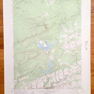 May include: A vintage topographic map of the Pocono Mountains in Pennsylvania, showing the area around the Pocono Pines Reservoir. The map is printed on green and white paper and includes contour lines, roads, and other geographical features. The map is titled "Pocono Pines, Pa."