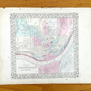 Könnte beinhalten: Antike Karte mit dem Titel "Plan von Cincinnati and Vicinity". Die Karte zeigt eine detaillierte Darstellung der Stadt und ihrer Umgebung, mit Straßen, Gebäuden und dem Ohio River. Die Karte ist von einem dekorativen Rahmen umgeben und auf gealtertem Papier gedruckt.
