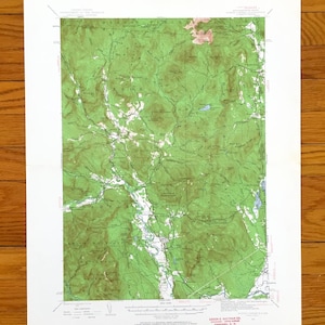 Könnte beinhalten: Eine detaillierte topografische Karte mit grünen und weißen Geländemerkmalen, einschließlich Flüssen und Bergen. Die Karte ist auf weißem Papier gedruckt und scheint ein Vintage- oder antikes Stück zu sein. Die Karte hat Text unten.