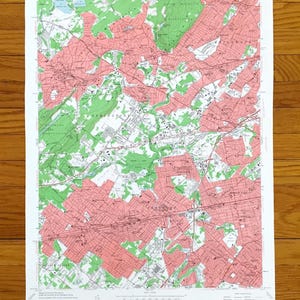 Może przedstawiać: Zabytkowa mapa topograficzna ze szczegółowym widokiem obszaru, z połączeniem odcieni zieleni i różu. Mapa zawiera tekst wskazujący, że pochodzi z Departamentu Spraw Wewnętrznych Stanów Zjednoczonych. Mapa jest wydrukowana na białym papierze.