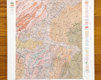 Puede incluir: Un mapa geológico vintage de la zona de Roan Mountain en Carolina del Norte y Tennessee. El mapa está impreso en negro, blanco, rojo, verde, azul y amarillo. El mapa muestra las diferentes formaciones geológicas de la zona. El mapa se titula "Economic Geology Sheet" e incluye una leyenda con diferentes símbolos geológicos.