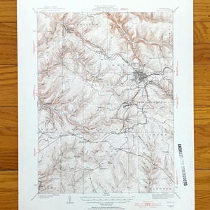 以下が含まれることがあります： 茶色と白の等高線で描かれたヴィンテージ地形図。詳細な地理的エリアを示しています。 ハミルトンやウェストなどの地名、グリッドオーバーレイ、地球科学部のテキストが含まれています。