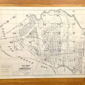 Puede incluir: Un mapa clave antiguo de Somers Point, condado de Atlantic, NJ, con diseños detallados de calles, vías fluviales y secciones numeradas. El mapa, impreso en tinta negra, incluye "Great Egg Harbor Bay" y "Main Channel". El mapa está en una hoja rectangular.