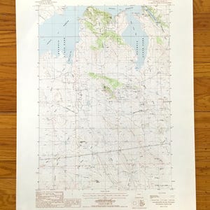 May include: A detailed topographic map of a region, featuring contour lines, water bodies, and labeled areas. The map includes text indicating the map's origin and scale, with a focus on geographical features.
