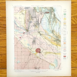 Pode incluir: Uma folha de geologia aérea vintage, exibindo um mapa detalhado de uma região com diversas cores e padrões indicando formações geológicas. O mapa inclui rótulos de texto e uma legenda, com foco na região de Chicago e Indiana.
