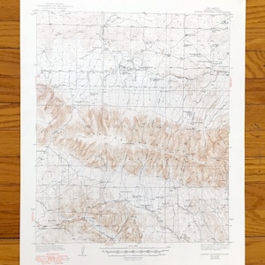 Peut inclure: Une carte topographique vintage des montagnes Capitan au Nouveau-Mexique. La carte présente des courbes de niveau détaillées, des routes et des noms de lieux, imprimés en nuances de brun et de bleu sur papier blanc. La carte est une représentation détaillée du terrain.