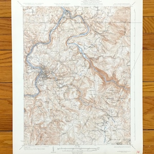 May include: A vintage topographic map of the area around the town of Morgantown, West Virginia. The map shows the surrounding rivers, roads, and elevation changes. The map is printed on paper and has a scale bar and a legend.