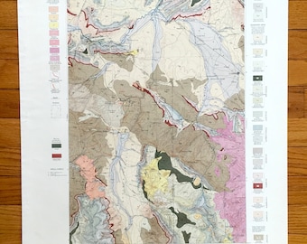 Puede incluir: Un mapa geológico del área de Three Forks en Montana, que muestra diferentes formaciones rocosas y características geológicas. El mapa está en negro, blanco y varios tonos de rosa, azul, verde, amarillo y marrón.